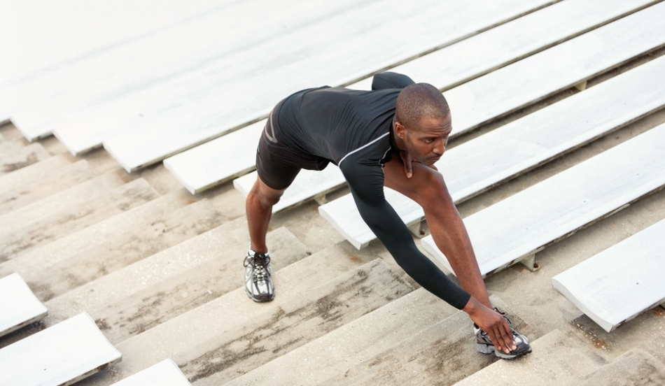 Athlete stretching on stadium steps