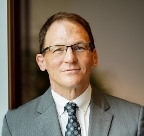white man smiles at camera